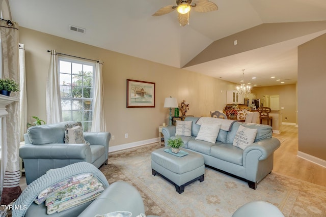 living room with light hardwood / wood-style flooring, ceiling fan with notable chandelier, and vaulted ceiling