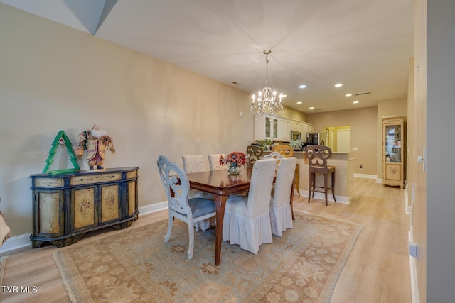 dining room with a chandelier and light hardwood / wood-style flooring