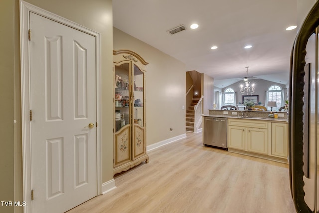 kitchen with dishwasher, light hardwood / wood-style flooring, cream cabinets, vaulted ceiling, and decorative light fixtures