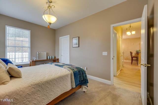 carpeted bedroom with a notable chandelier