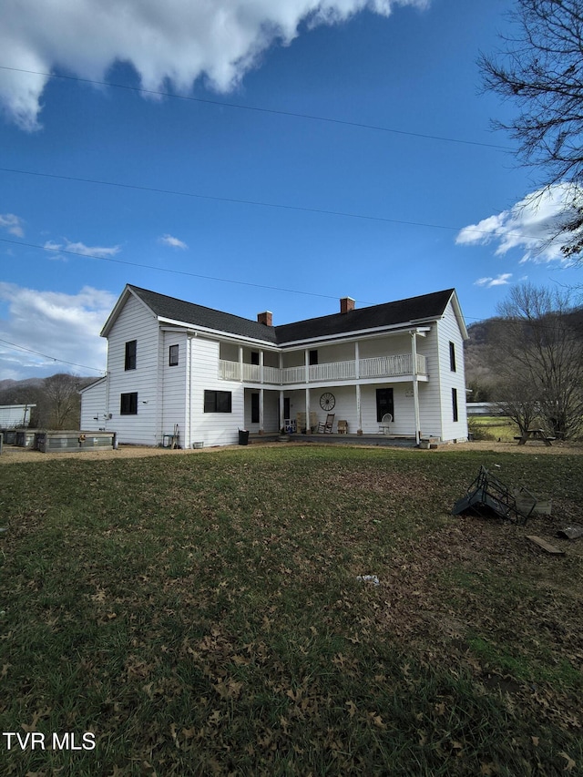 back of property featuring a lawn and a patio area