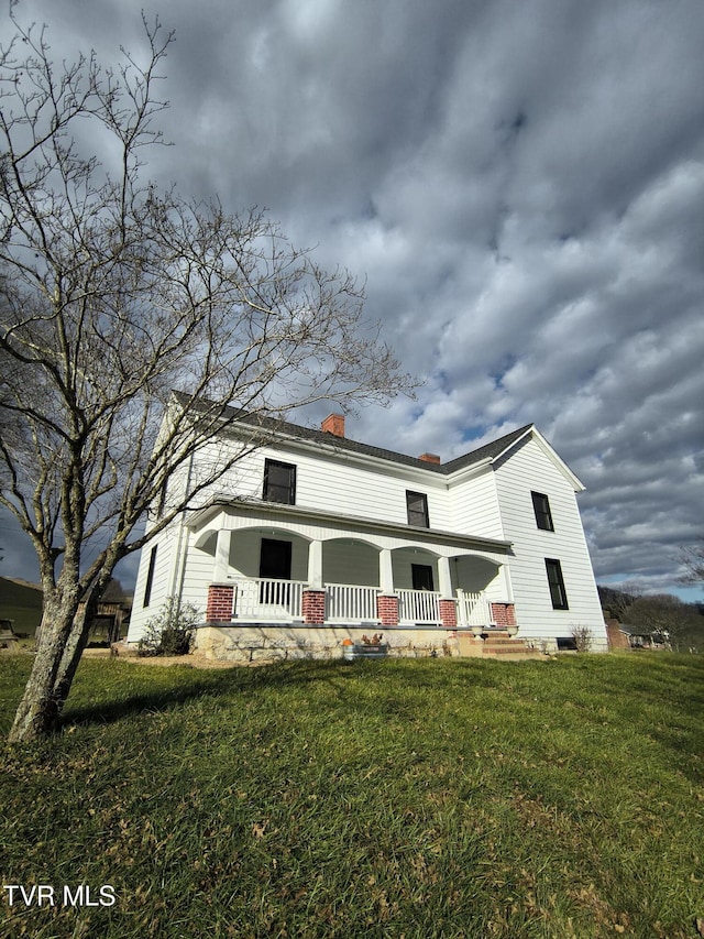 view of front facade with covered porch and a front lawn