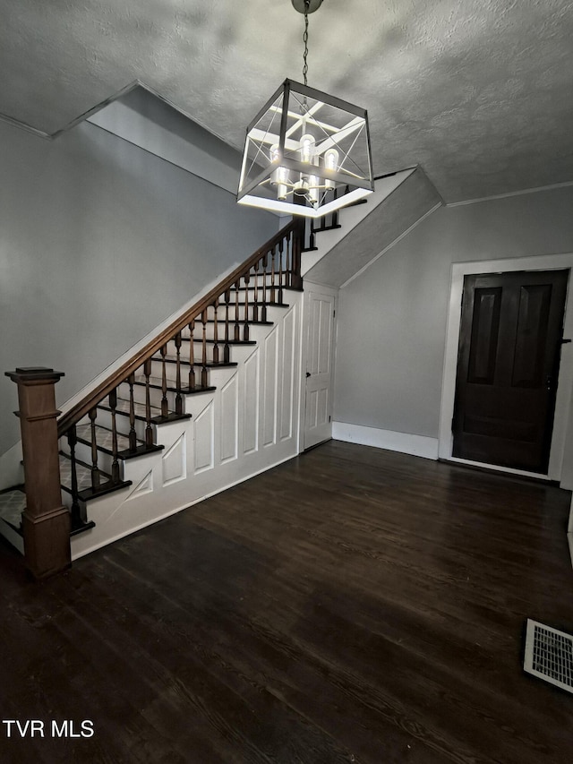 interior space featuring wood-type flooring, a textured ceiling, and a chandelier