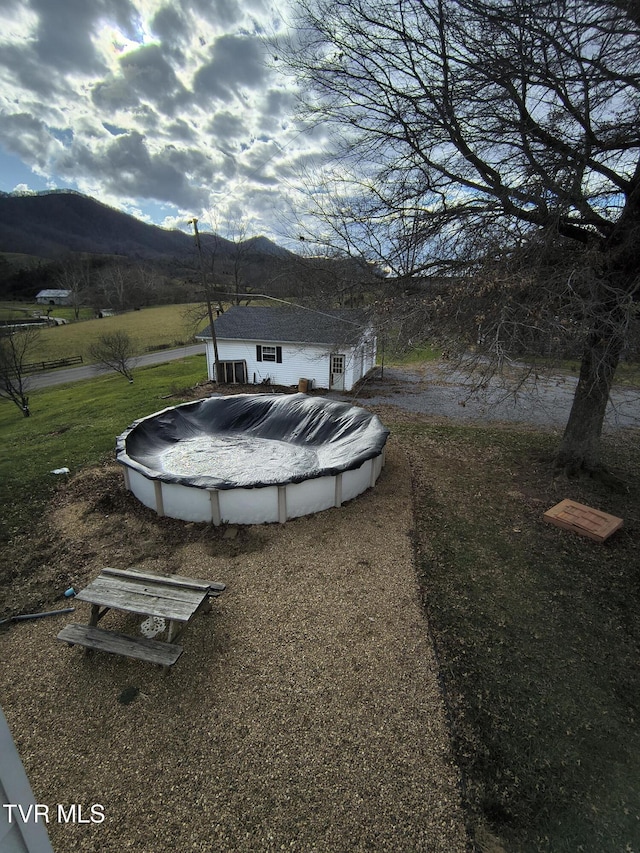 view of yard with a mountain view and a covered pool