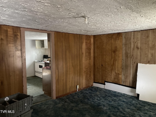 unfurnished bedroom featuring dark colored carpet, a textured ceiling, and wood walls