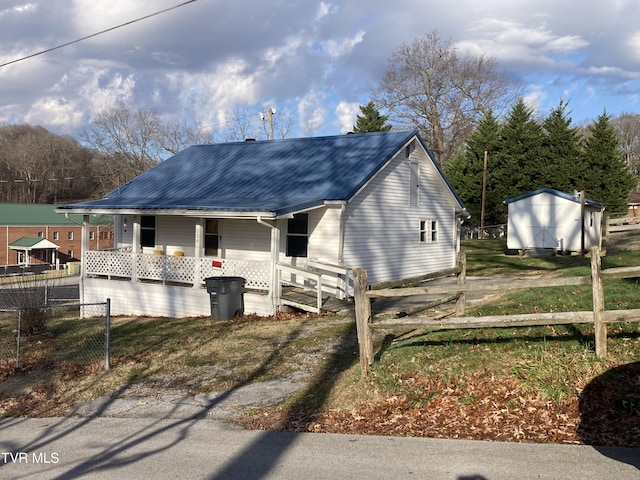 view of front facade with covered porch and a shed