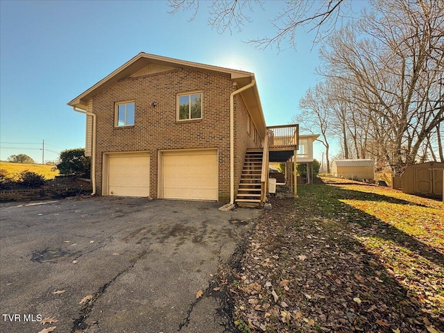 view of property exterior featuring a deck, a storage shed, and a garage