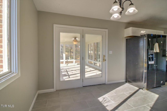 doorway with light tile patterned flooring and a notable chandelier