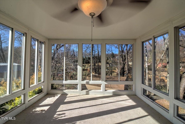 unfurnished sunroom with a wealth of natural light and ceiling fan