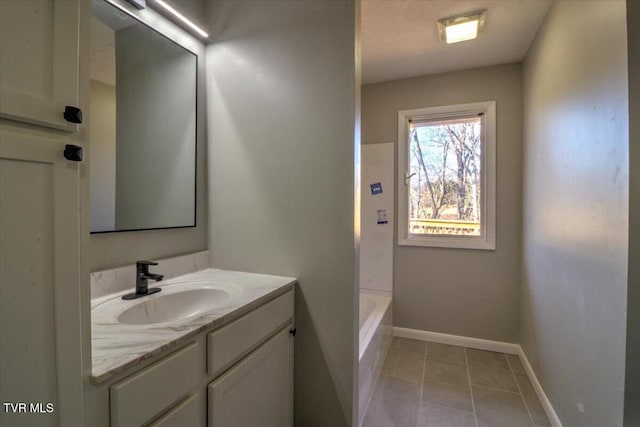 bathroom featuring tile patterned flooring, vanity, and a tub