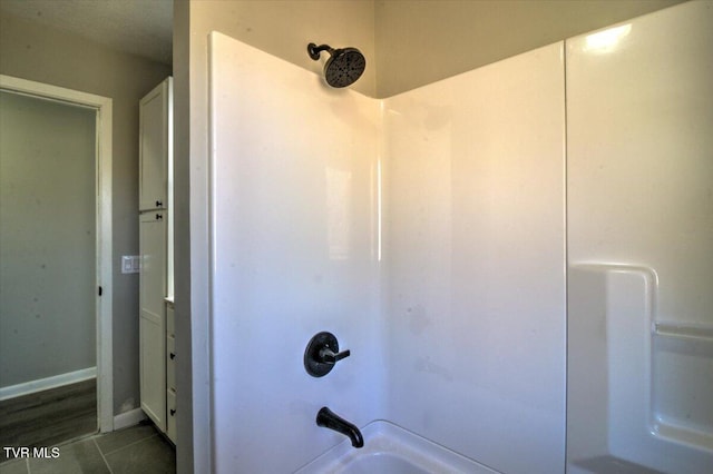 bathroom with tile patterned floors and shower / washtub combination