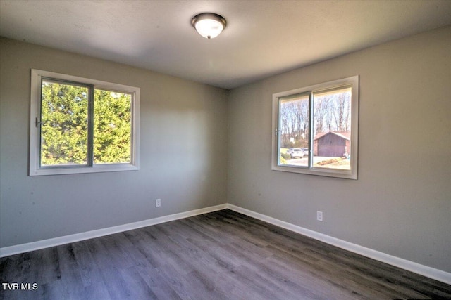 unfurnished room featuring dark hardwood / wood-style flooring and a wealth of natural light