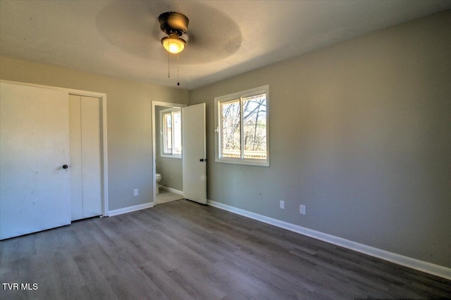 unfurnished bedroom featuring hardwood / wood-style flooring, ceiling fan, and ensuite bath