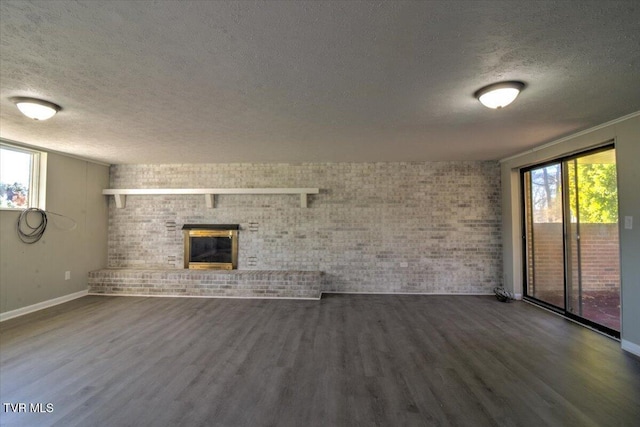 unfurnished living room with a textured ceiling, a brick fireplace, and a healthy amount of sunlight