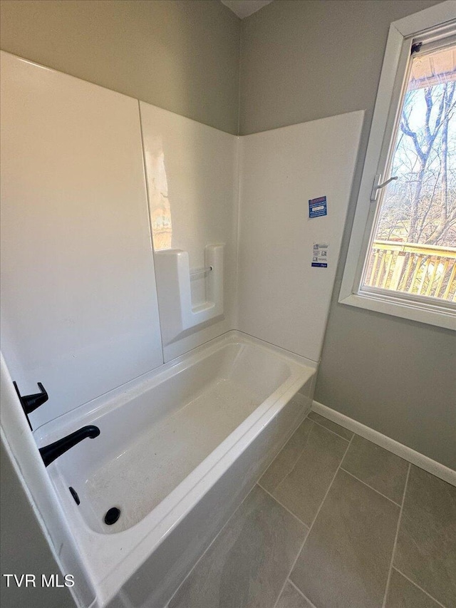 bathroom featuring tile patterned floors and a tub to relax in