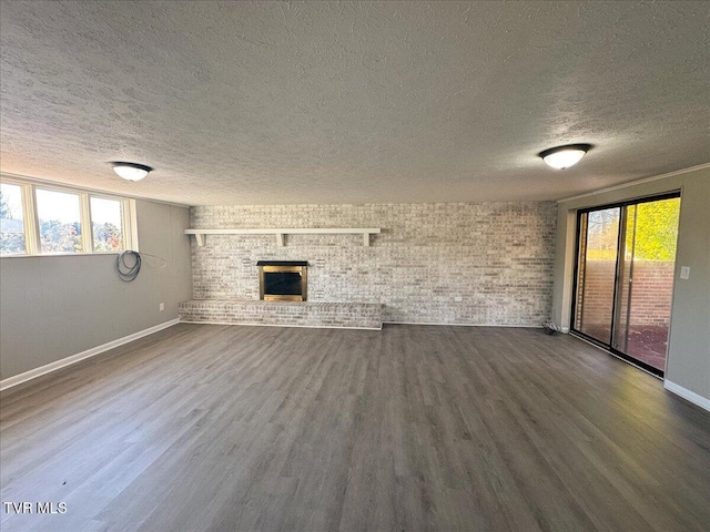 unfurnished living room with hardwood / wood-style flooring, a brick fireplace, and plenty of natural light