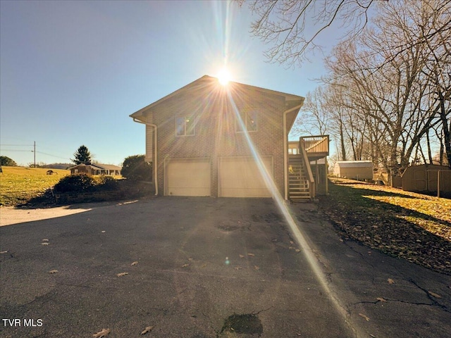 view of front of house with a wooden deck, a shed, and a garage