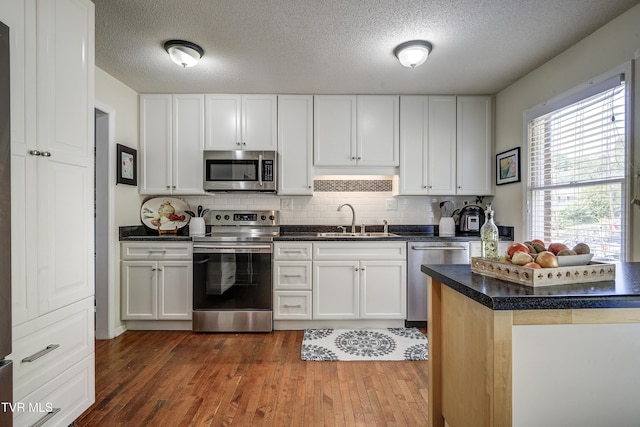 kitchen featuring white cabinets, dark hardwood / wood-style floors, sink, and appliances with stainless steel finishes