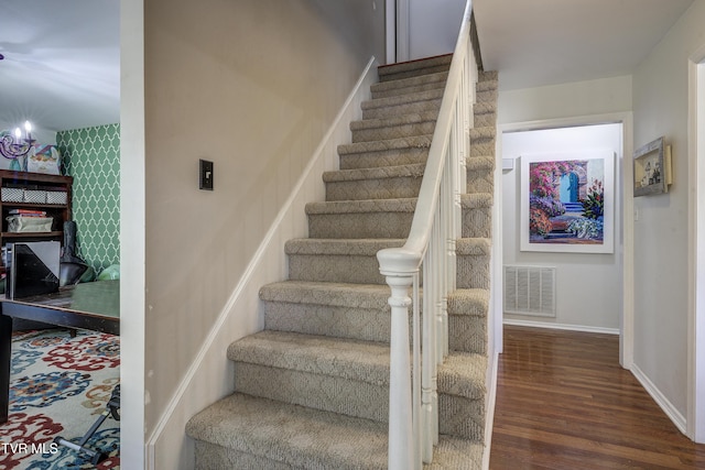 stairs with a chandelier and wood-type flooring