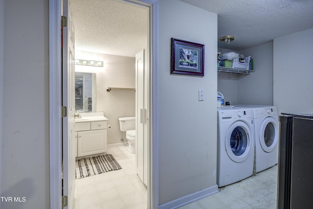 laundry room with washing machine and clothes dryer and a textured ceiling