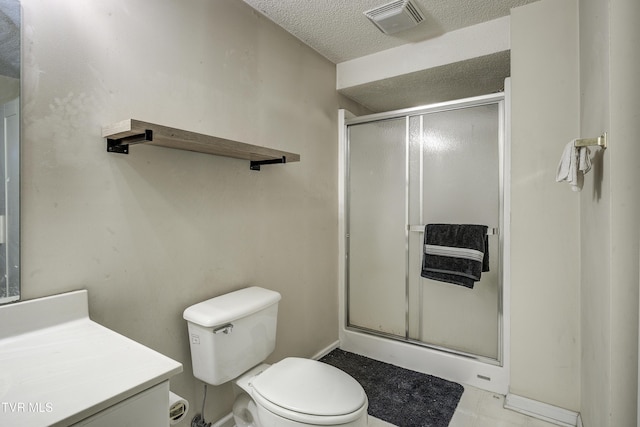 bathroom with vanity, a shower with shower door, a textured ceiling, and toilet