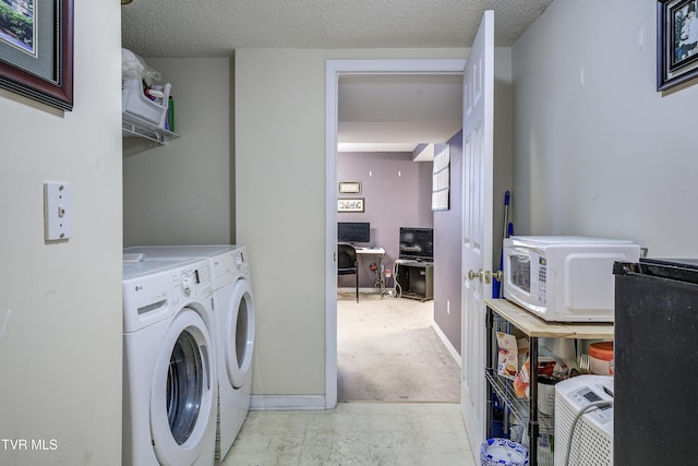 washroom featuring a textured ceiling and washing machine and clothes dryer