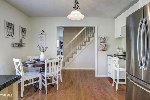 dining space featuring a textured ceiling and dark wood-type flooring