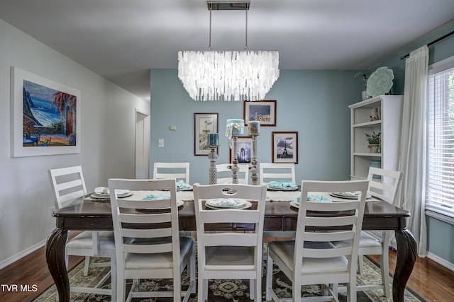 dining area with wood-type flooring and a chandelier