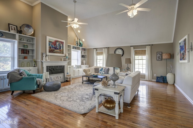 living room featuring a high end fireplace, hardwood / wood-style floors, and ceiling fan