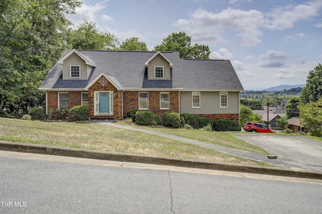 new england style home featuring a mountain view and a front yard