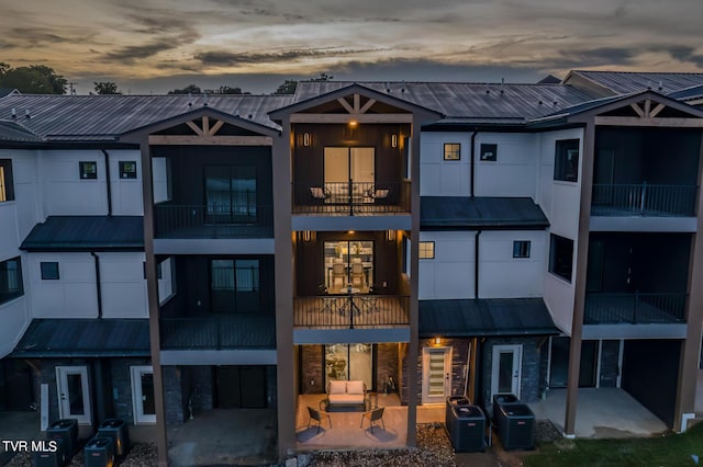 exterior space with central air condition unit, a balcony, and a patio