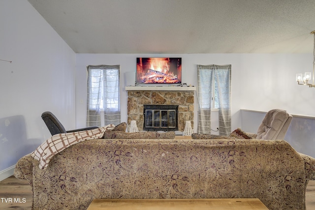 living room with hardwood / wood-style floors, a fireplace, a chandelier, and a textured ceiling