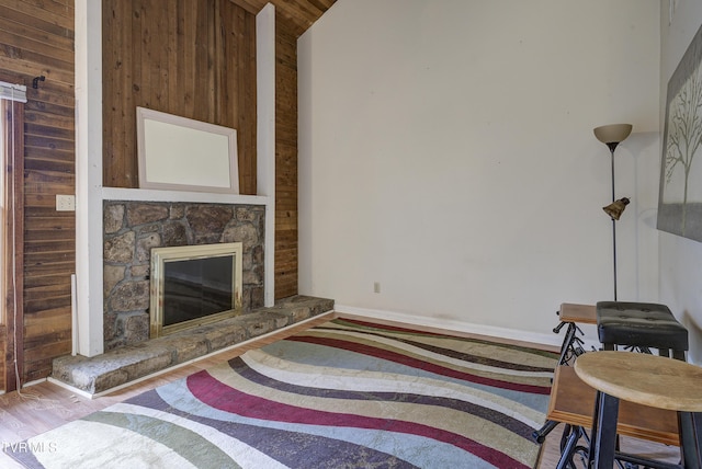 unfurnished living room featuring vaulted ceiling, a fireplace, and light hardwood / wood-style flooring