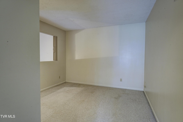 carpeted empty room with a textured ceiling