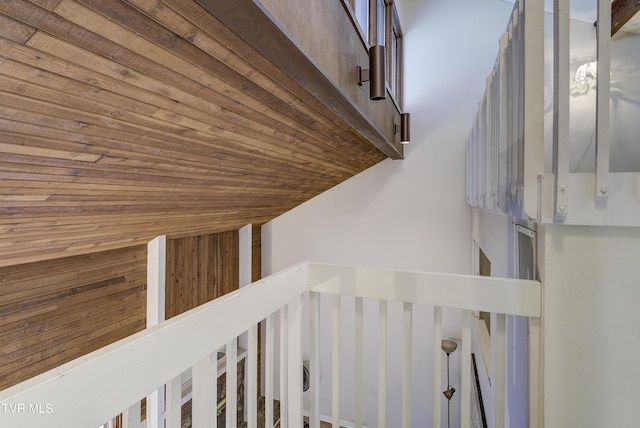 staircase featuring vaulted ceiling and wooden ceiling