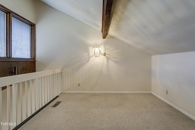 additional living space featuring carpet and lofted ceiling with beams