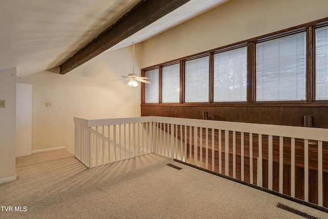 hall featuring carpet flooring, vaulted ceiling with beams, and plenty of natural light