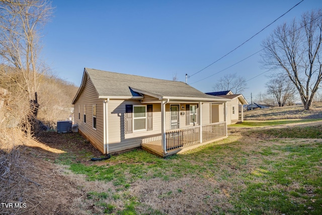 rear view of property with central AC, a yard, and covered porch