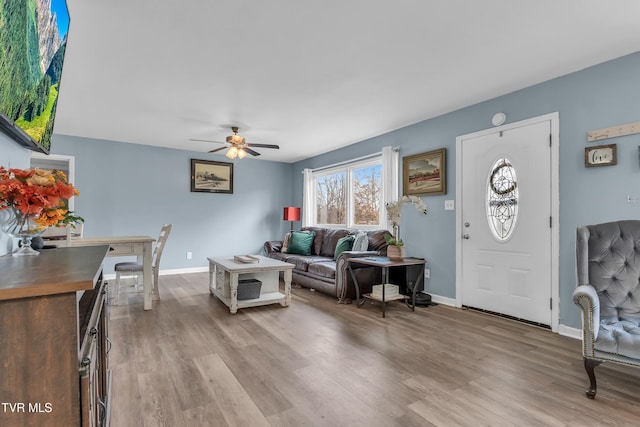 living room with light hardwood / wood-style floors and ceiling fan