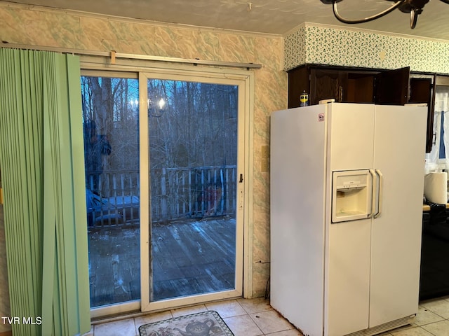 kitchen featuring dark brown cabinets, white refrigerator with ice dispenser, and light tile patterned floors