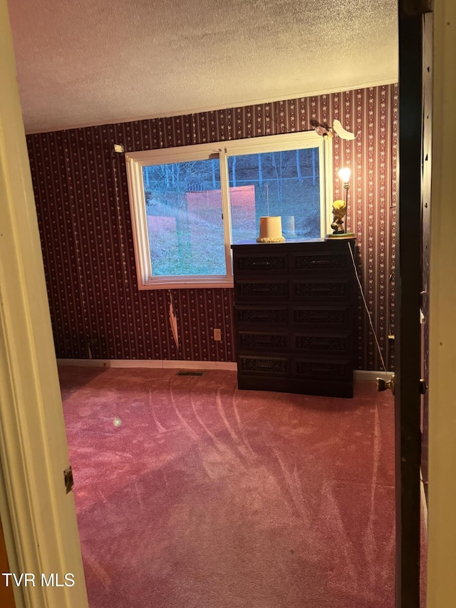 unfurnished bedroom featuring carpet floors and a textured ceiling