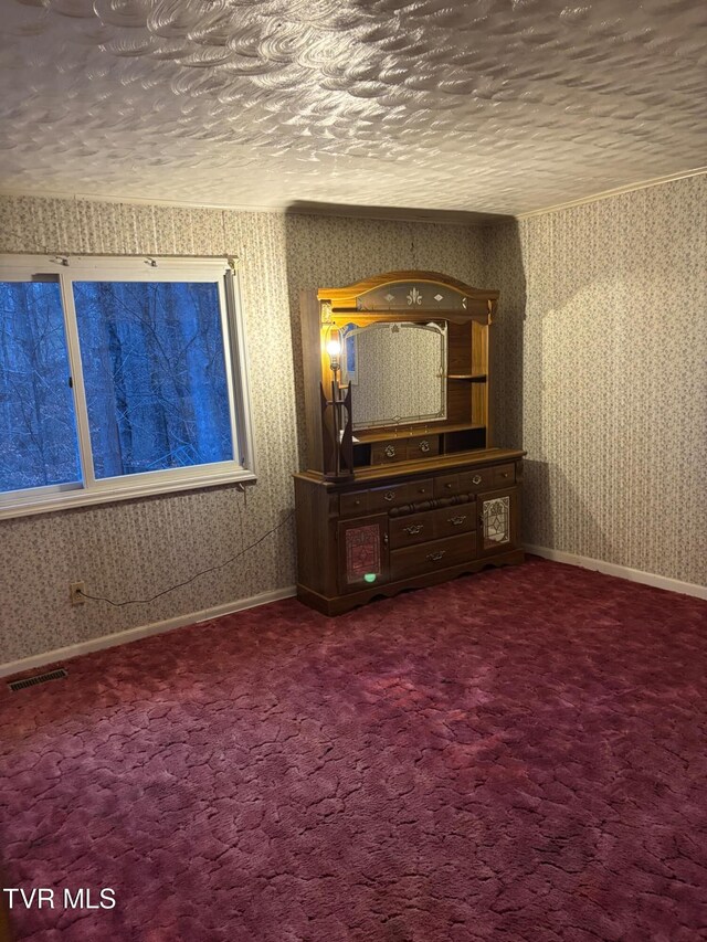 unfurnished bedroom featuring carpet flooring and a textured ceiling