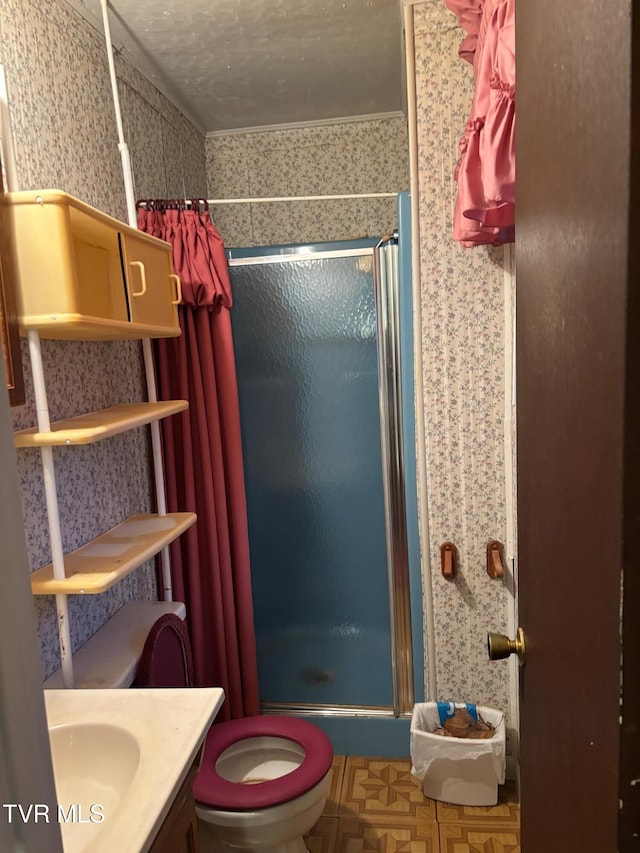 bathroom with vanity, a shower with shower door, a textured ceiling, and toilet