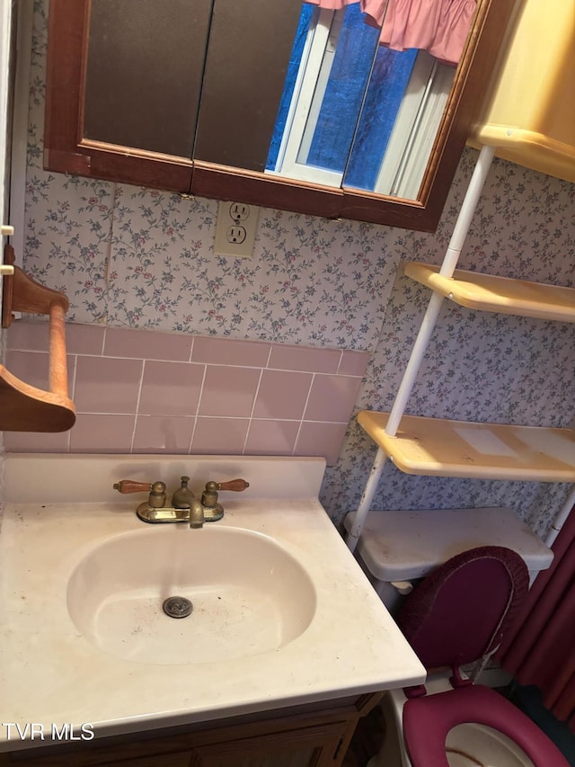 bathroom with vanity and tasteful backsplash