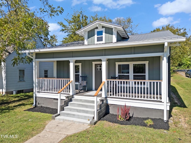 bungalow-style home with covered porch and a front lawn