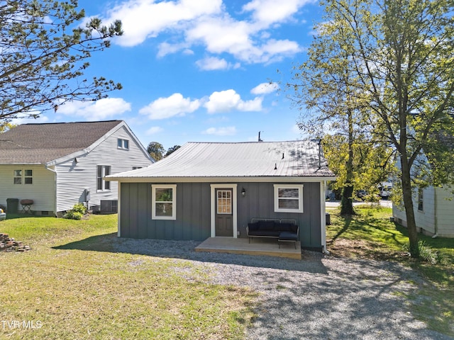 rear view of property featuring a yard and central air condition unit