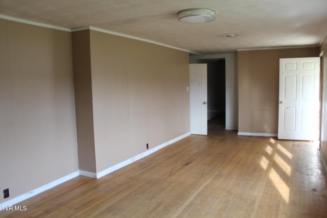 spare room featuring light hardwood / wood-style flooring and ornamental molding