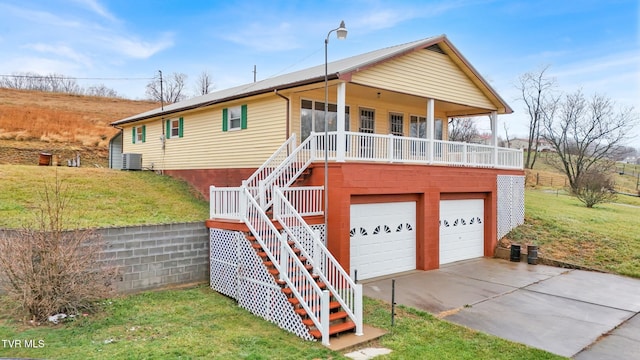 exterior space featuring a front lawn, covered porch, and a garage