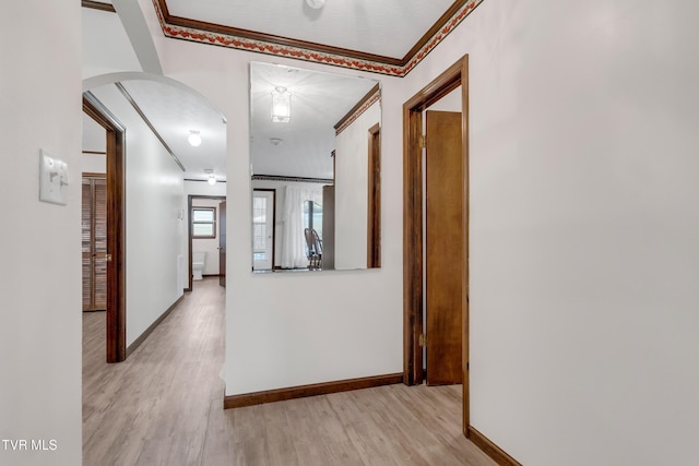 hallway featuring light hardwood / wood-style flooring and crown molding