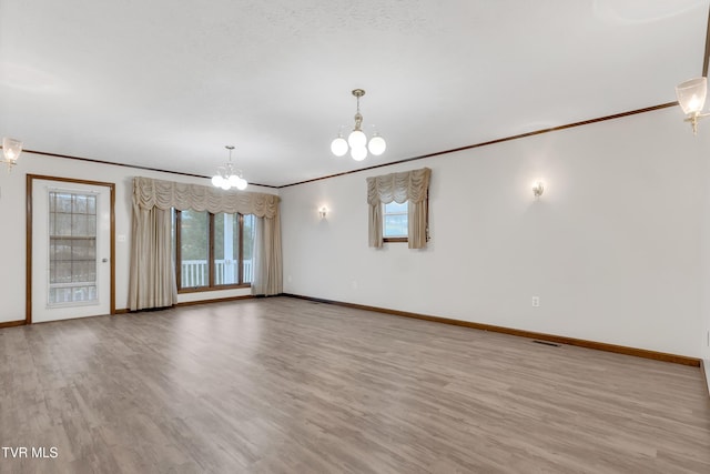 unfurnished room with ornamental molding, a chandelier, and light hardwood / wood-style floors